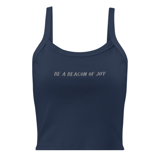 "Be a beacon of joy" printed on a solid navy blend women's micro-rib tanktop laying on a flat surface