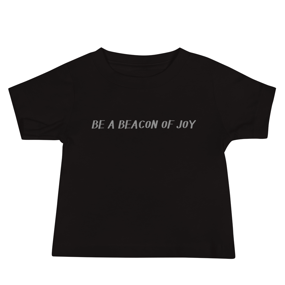 "Be a beacon of joy" printed on a black baby jersey short sleeve tee laying on a flat surface