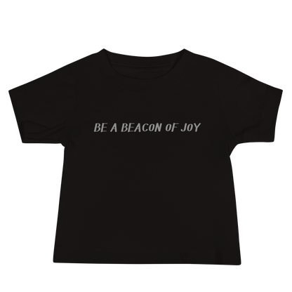 "Be a beacon of joy" printed on a black baby jersey short sleeve tee laying on a flat surface