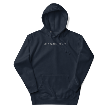 "Be a beacon of joy" printed on a navy blazer unisex hoodie laying on a flat surface with the hood up