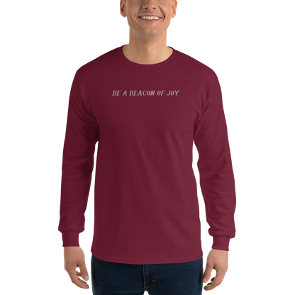 "Be a beacon of joy" printed on a maroon men's long sleeve shirt worn by a male