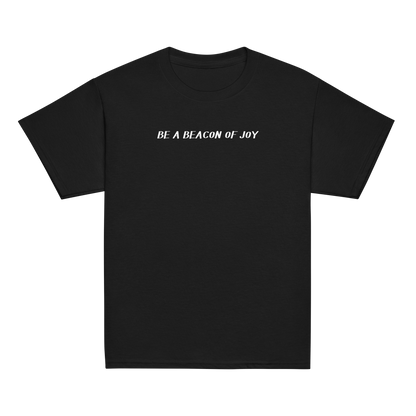 "Be a beacon of joy" printed on a black youth classic tee laying on a flat surface