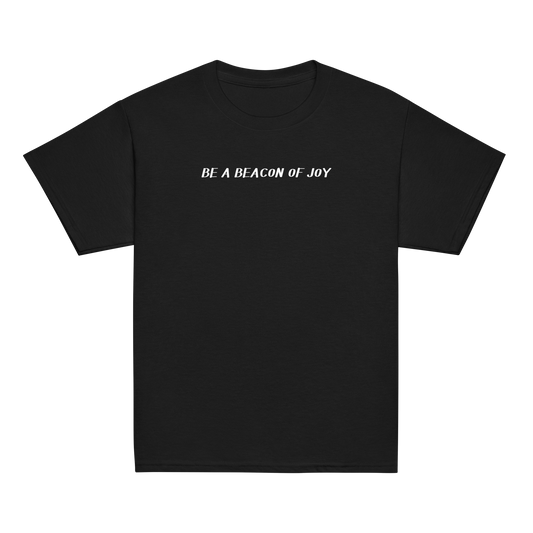"Be a beacon of joy" printed on a black youth classic tee laying on a flat surface