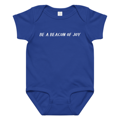 "Be a beacon of joy" printed on a royal baby jersey bodysuit laying on a flat surface amongst other clothes