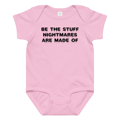 "Be the stuff nightmares are made of" printed on a pink baby jersey bodysuit laying on a flat surface amongst other clothes