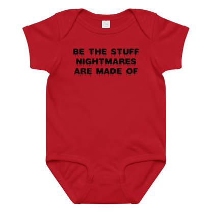 "Be the stuff nightmares are made of" printed on a red baby jersey bodysuit laying on a flat surface amongst other clothes
