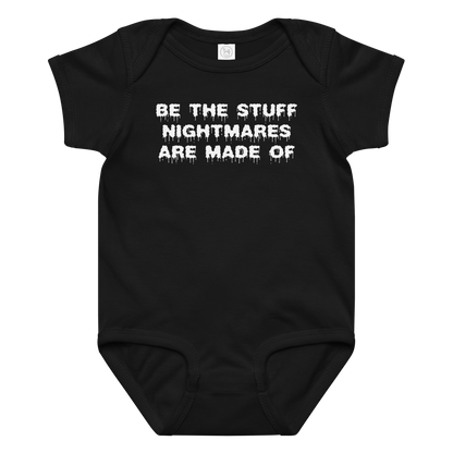 "Be the stuff nightmares are made of" printed on a black baby jersey bodysuit laying on a flat surface amongst other clothes