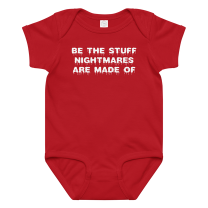 "Be the stuff nightmares are made of" printed on a red baby jersey bodysuit laying on a flat surface amongst other clothes