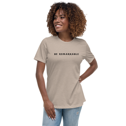 "Be remarkable" printed on a heather stone women's relaxed t-shirt worn by a female