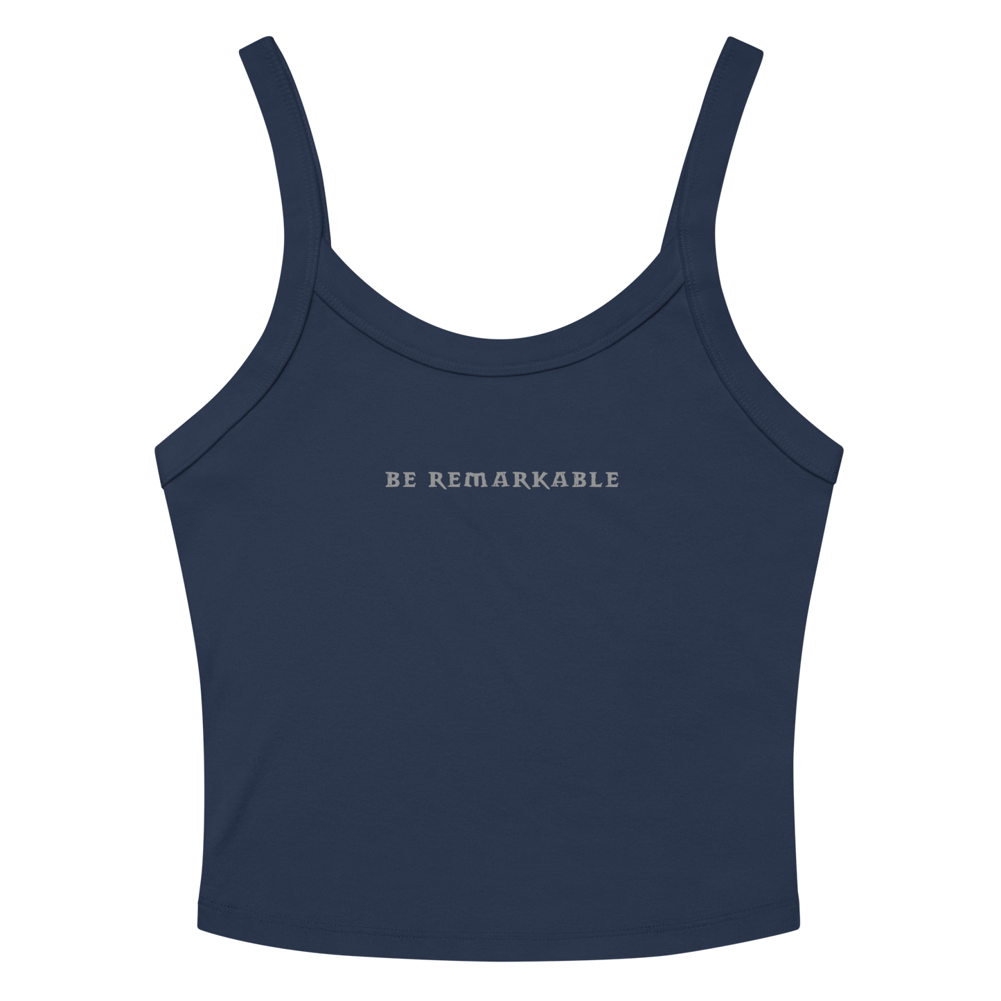 "Be remarkable" printed on a solid navy blend women's micro-rib tanktop laying on a flat surface amongst sunglasses and shorts