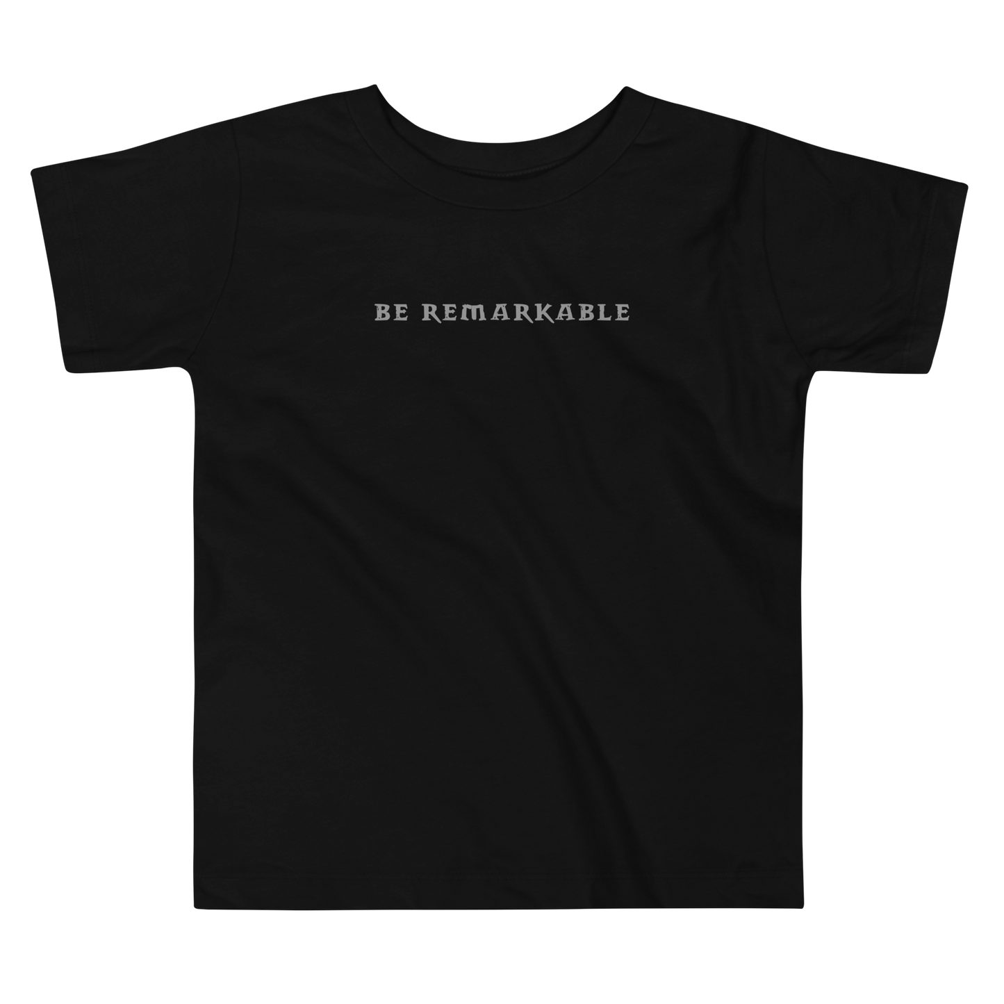 "Be remarkable" printed on a black toddler short sleeve tee laying on a flat surface