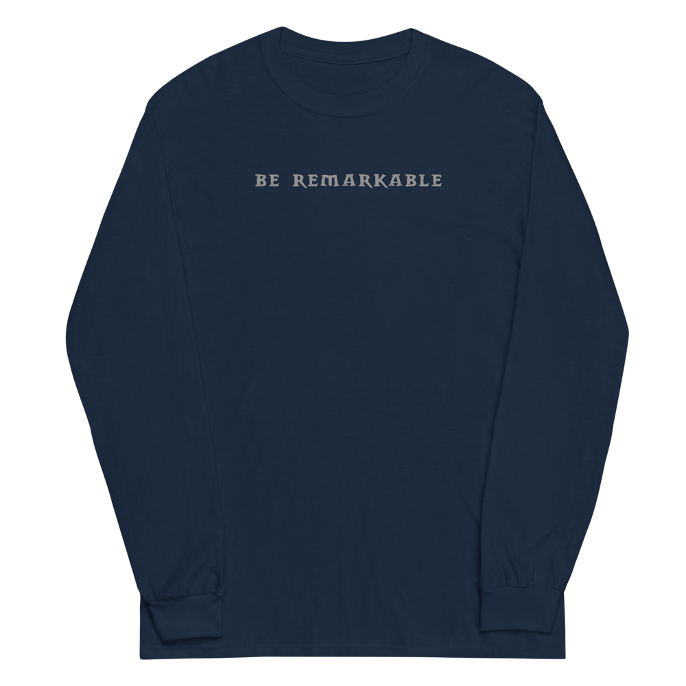 "Be remarkable" printed on a navy men's long sleeve shirt laying on a flat surface