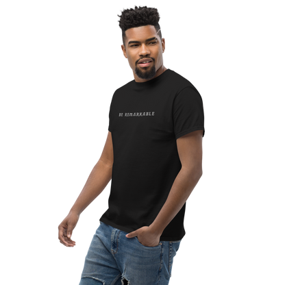 "Be remarkable" printed on a black unisex classic tee worn by a male
