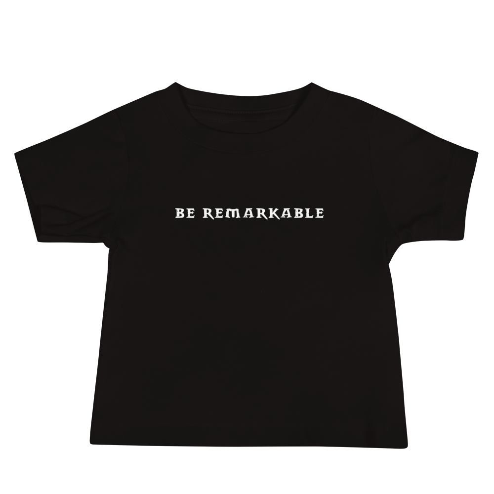 "Be remarkable" printed on a black baby jersey short sleeve tee laying on a flat surface