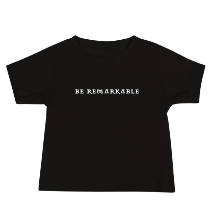"Be remarkable" printed on a black baby jersey short sleeve tee laying on a flat surface