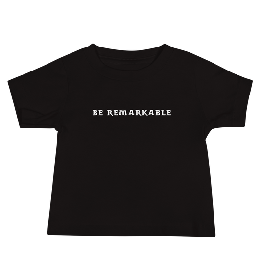 "Be remarkable" printed on a black baby jersey short sleeve tee laying on a flat surface