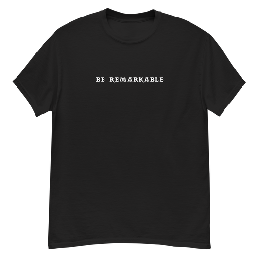 "Be remarkable" printed on a black unisex classic tee laying on a flat surface