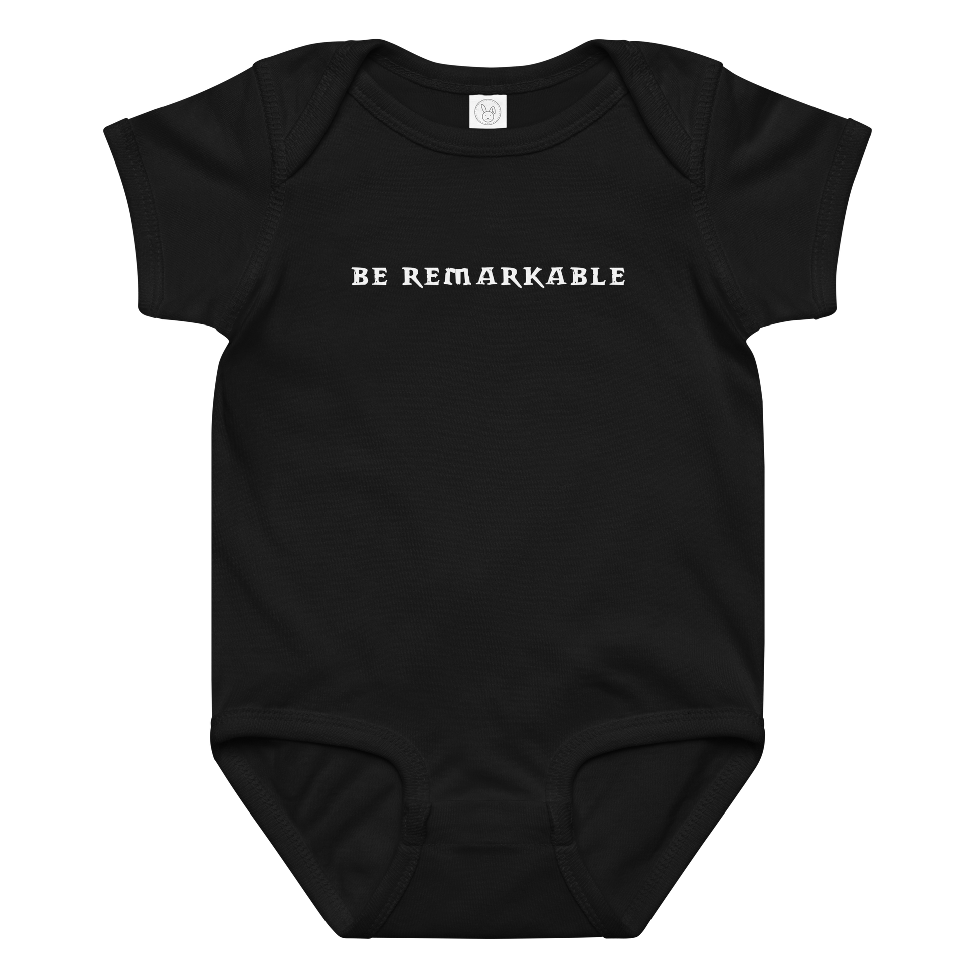 "Be remarkable" printed on a black baby jersey bodysuit laying on a flat surface amongst other clothes