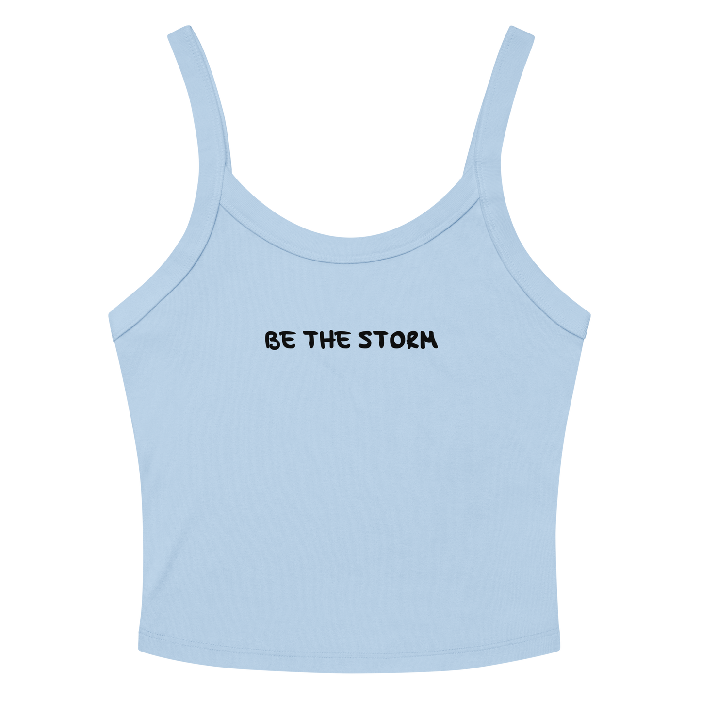 "Be the storm" printed on a solid baby blue blend women's micro-rib tanktop laying on a flat surface amongst sunglasses and shorts