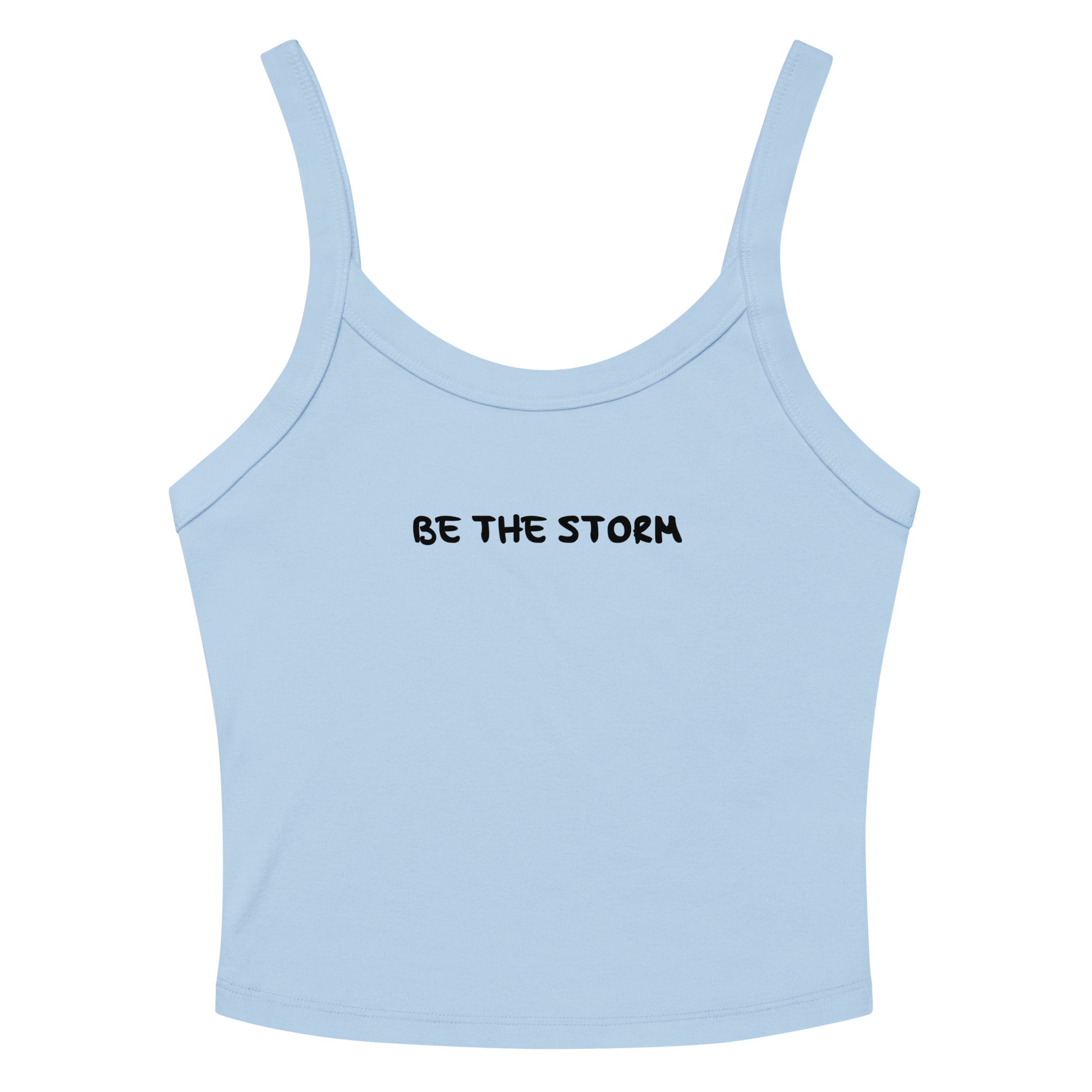 "Be the storm" printed on a solid baby blue blend women's micro-rib tanktop laying on a flat surface amongst sunglasses and shorts