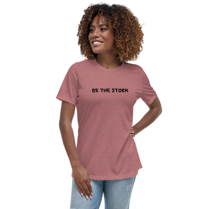 "Be the storm" printed on a heather mauve women's relaxed t-shirt worn by a female