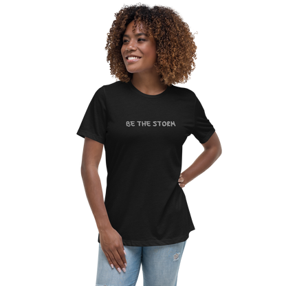 "Be the storm" printed on a black women's relaxed t-shirt worn by a female