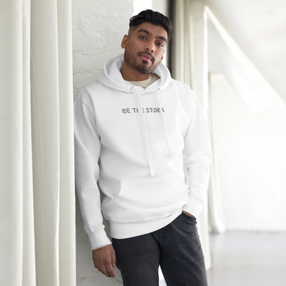 "Be the storm" printed on a white unisex hoodie worn by a male