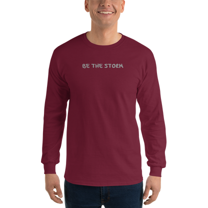 "Be the storm" printed on a maroon men's long sleeve shirt worn by a male