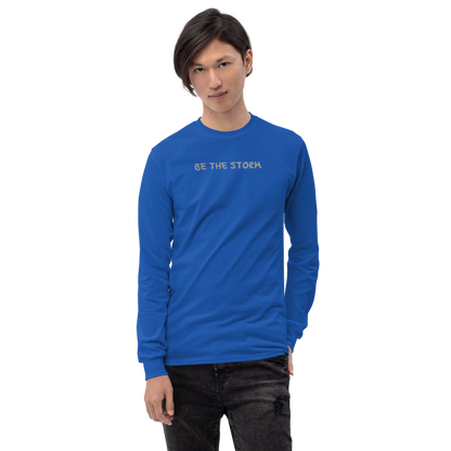 "Be the storm" printed on a royal men's long sleeve shirt worn by a male