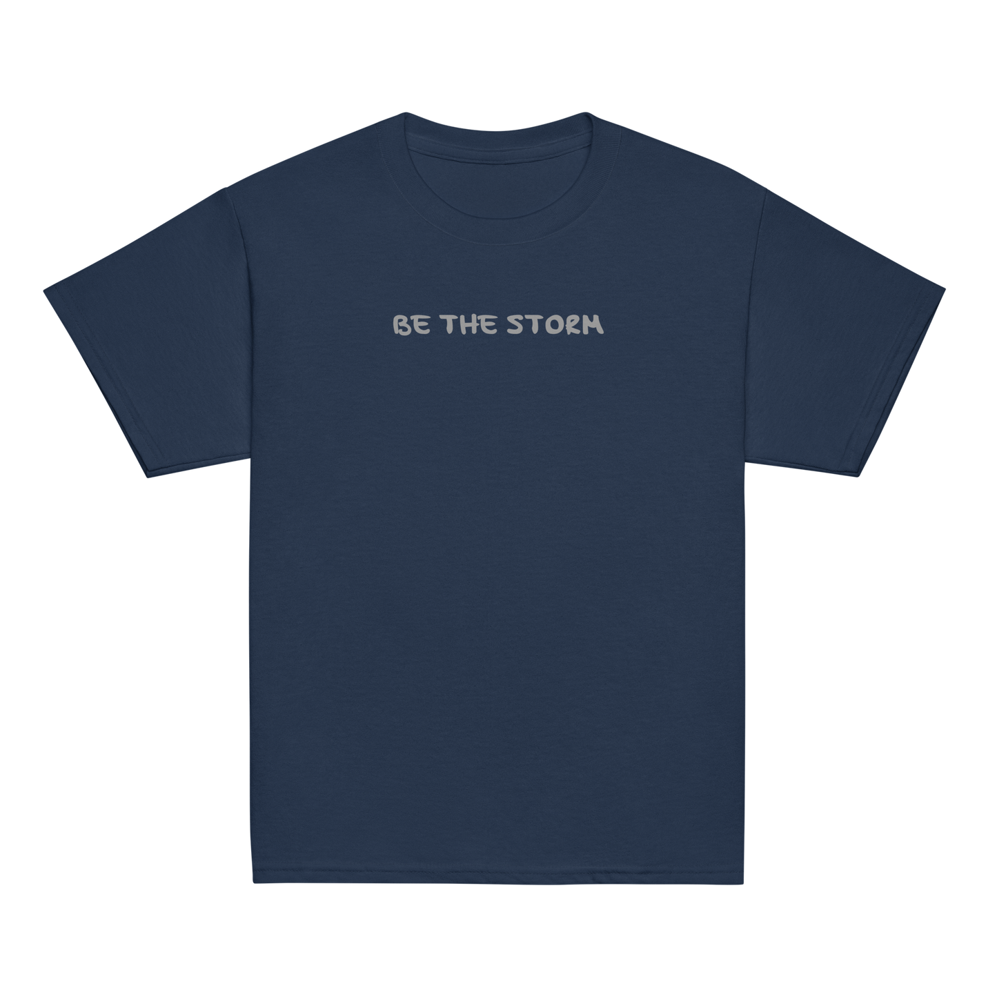 "Be the storm" printed on a navy youth classic tee laying on a flat surface