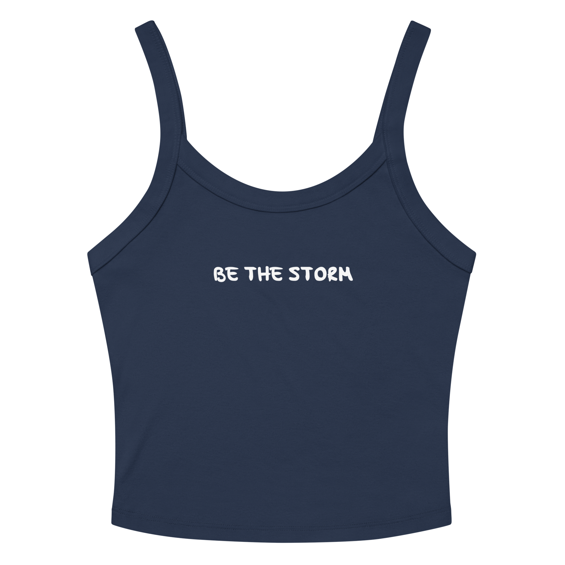 "Be the storm" printed on a solid navy blend women's micro-rib tanktop laying on a flat surface amongst sunglasses and shorts