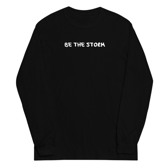 "Be the storm" printed on a black men's long sleeve shirt laying on a flat surface