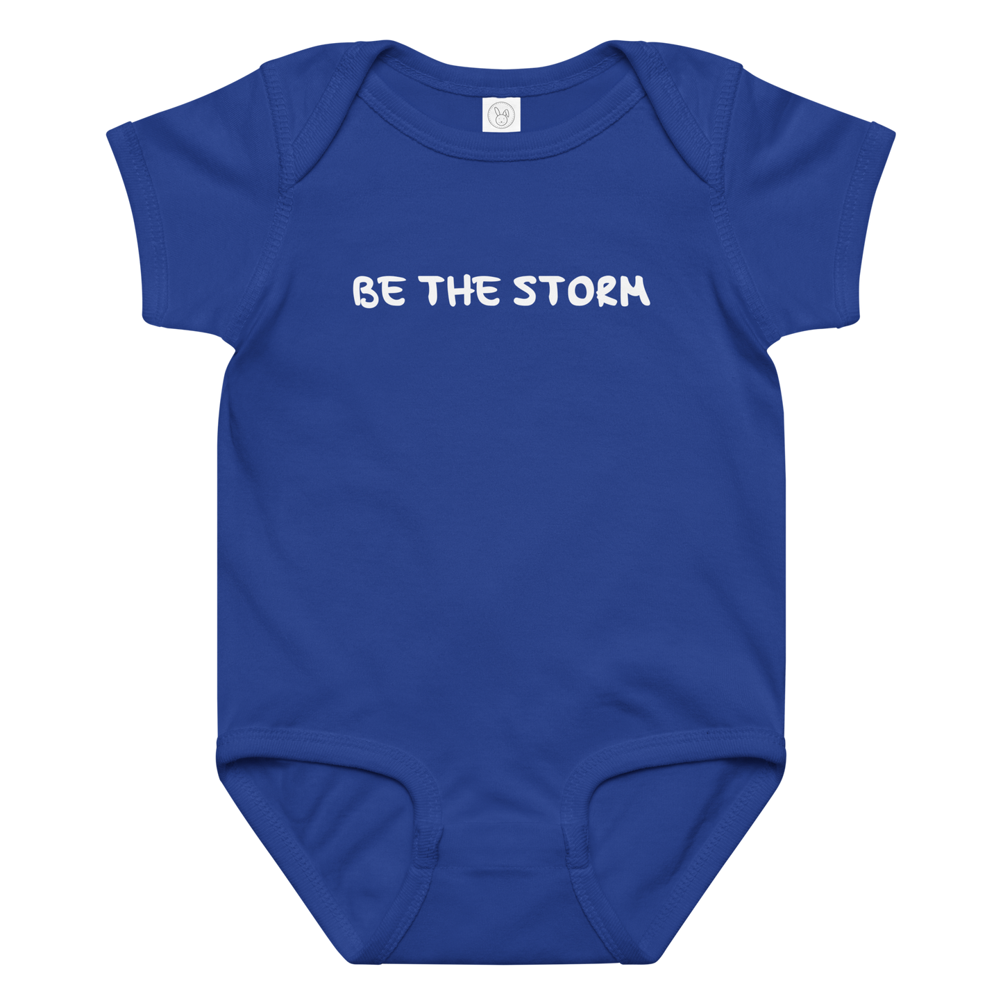 "Be the storm" printed on a royal baby jersey bodysuit laying on a flat surface amongst other clothes