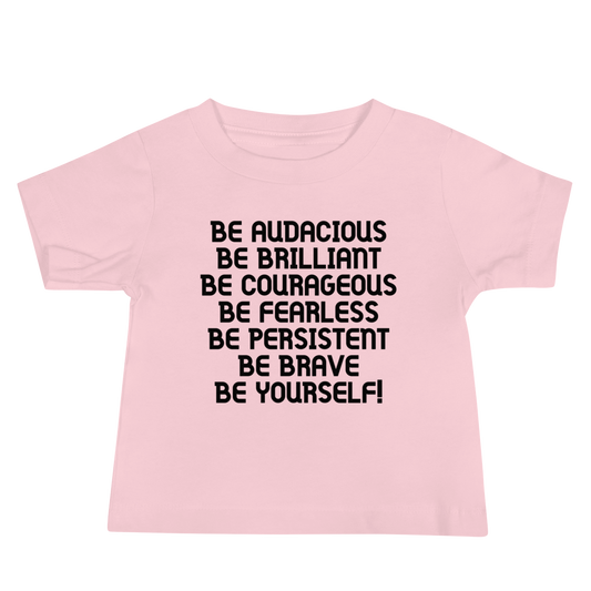 "Be Audacious Be Brilliant Be Courageous Be Fearless Be Persistent Be Brave Be Yourself!" printed on a pink baby jersey short sleeve tee laying on a flat surface