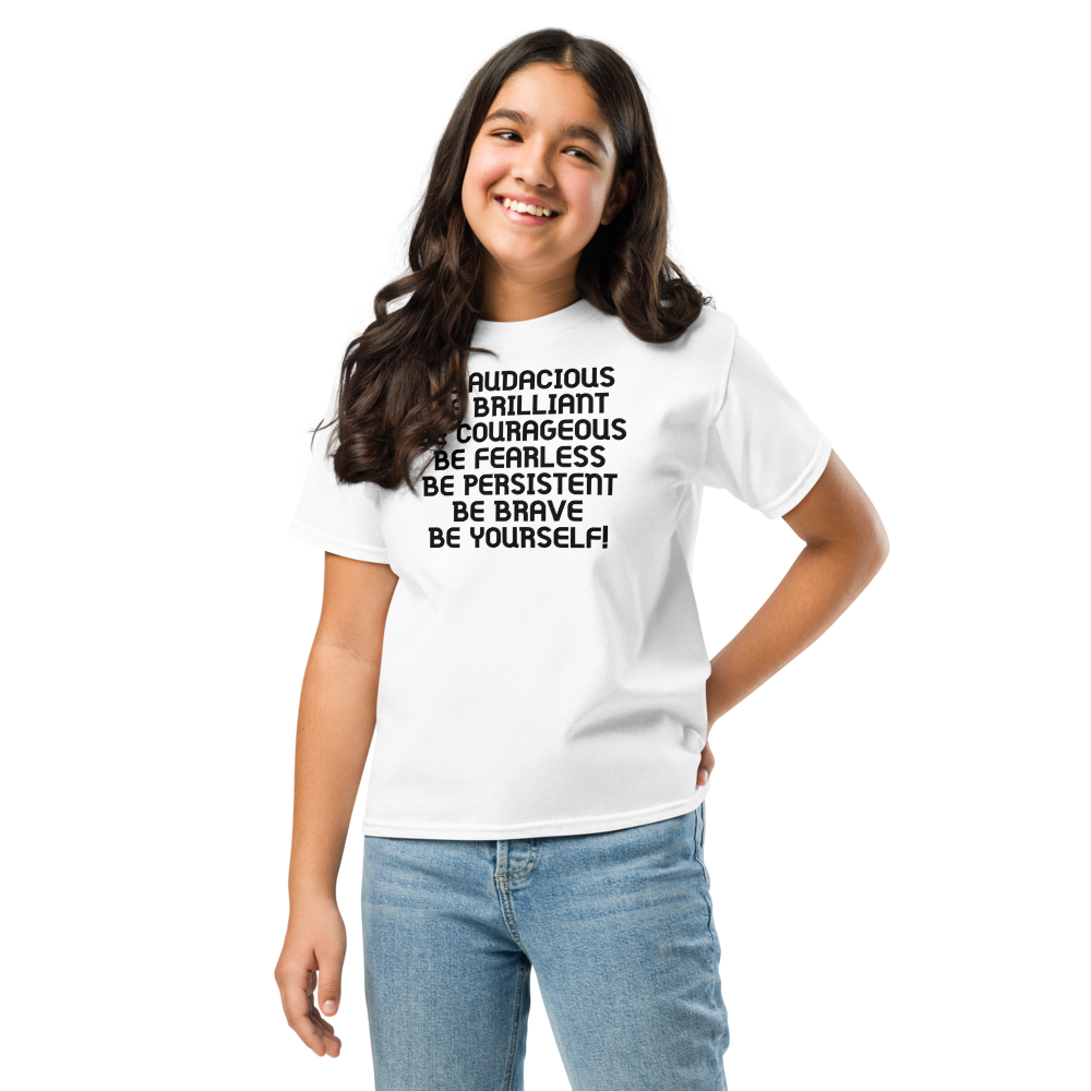 "Be Audacious Be Brilliant Be Courageous Be Fearless Be Persistent Be Brave Be Yourself!" printed on a white youth classic tee worn by a female