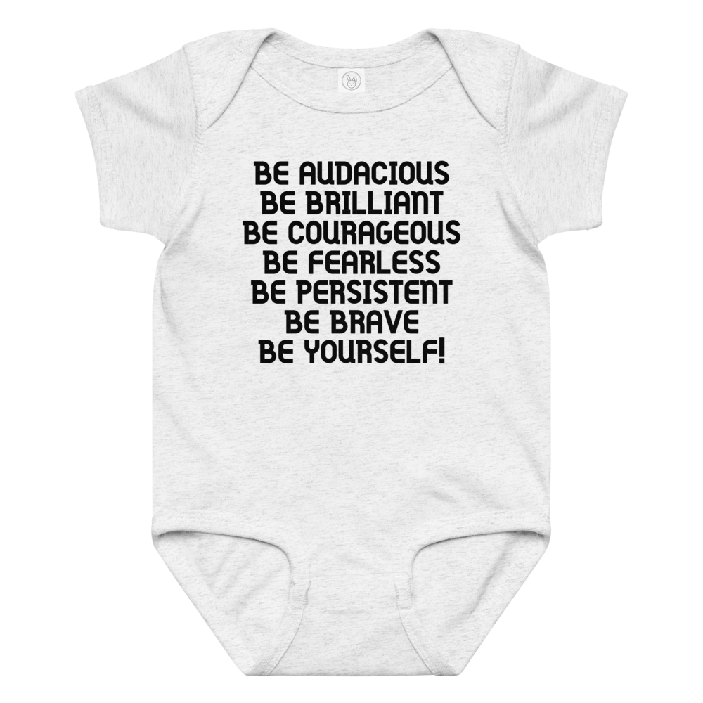 "Be Audacious Be Brilliant Be Courageous Be Fearless Be Persistent Be Brave Be Yourself!" printed on a ash baby jersey bodysuit laying on a flat surface amongst other clothes