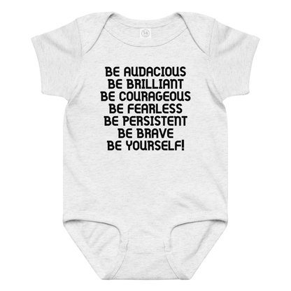 "Be Audacious Be Brilliant Be Courageous Be Fearless Be Persistent Be Brave Be Yourself!" printed on a ash baby jersey bodysuit laying on a flat surface amongst other clothes