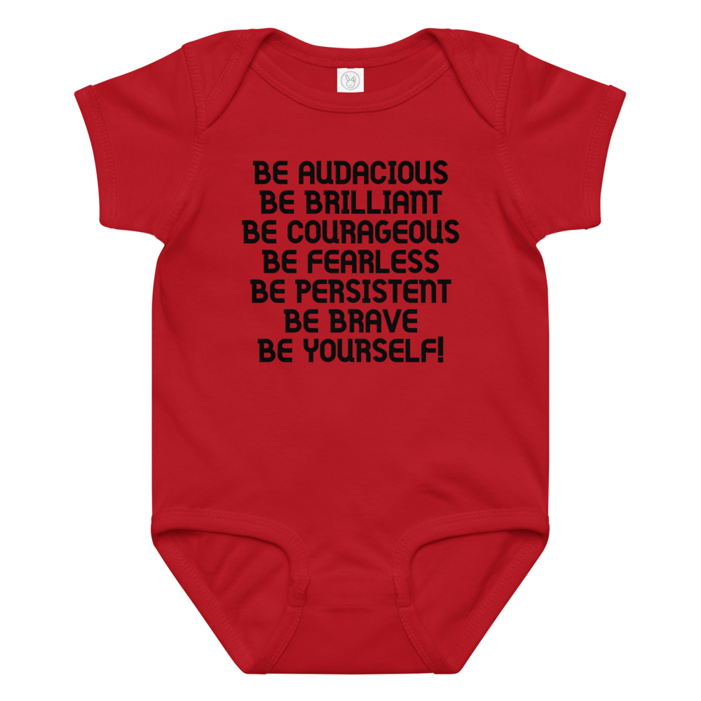 "Be Audacious Be Brilliant Be Courageous Be Fearless Be Persistent Be Brave Be Yourself!" printed on a red baby jersey bodysuit laying on a flat surface amongst other clothes