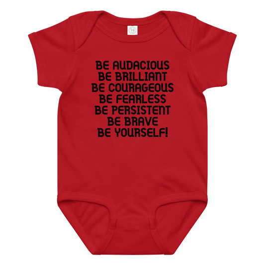 "Be Audacious Be Brilliant Be Courageous Be Fearless Be Persistent Be Brave Be Yourself!" printed on a red baby jersey bodysuit laying on a flat surface amongst other clothes