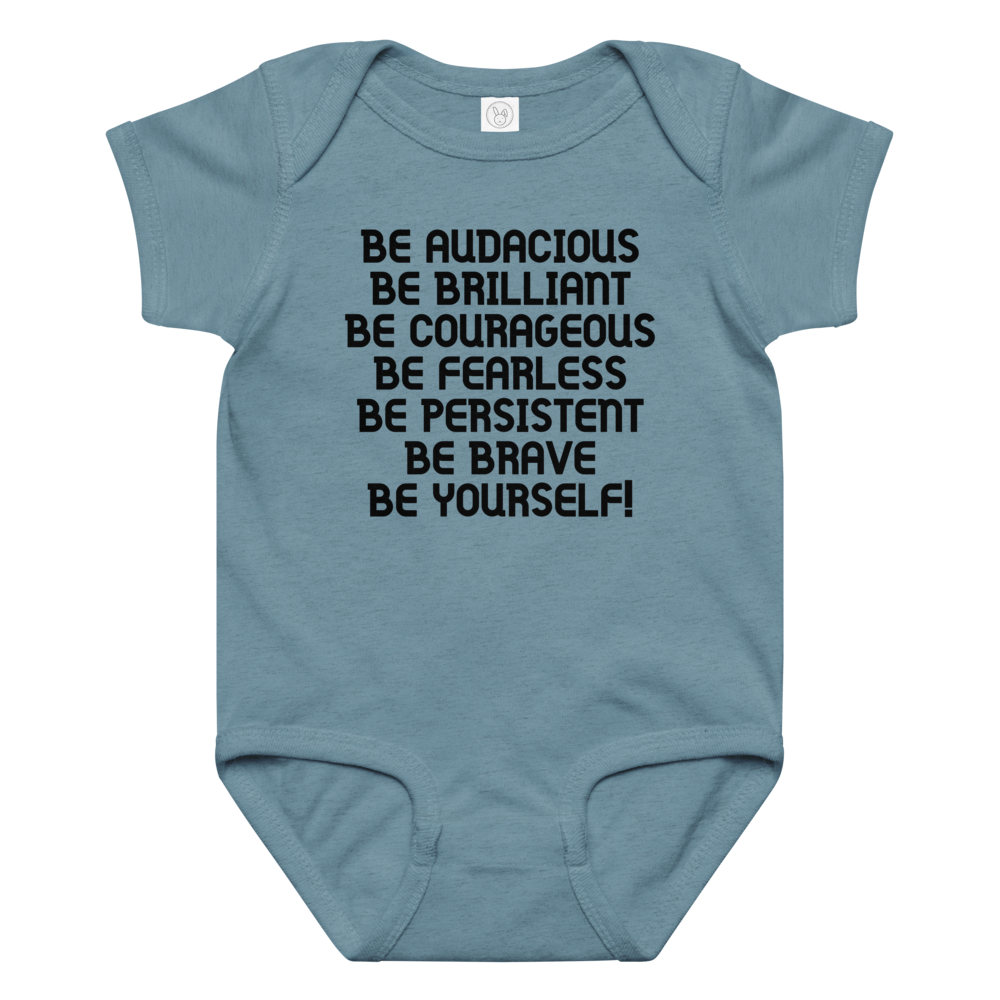 "Be Audacious Be Brilliant Be Courageous Be Fearless Be Persistent Be Brave Be Yourself!" printed on a vintage indigo baby jersey bodysuit laying on a flat surface amongst other clothes