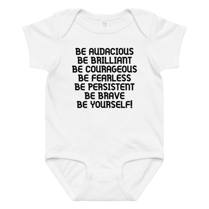 "Be Audacious Be Brilliant Be Courageous Be Fearless Be Persistent Be Brave Be Yourself!" printed on a white baby jersey bodysuit laying on a flat surface amongst other clothes