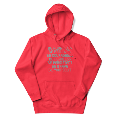 "Be Audacious Be Brilliant Be Courageous Be Fearless Be Persistent Be Brave Be Yourself!" printed on a team red unisex hoodie laying on a flat surface with the hood up
