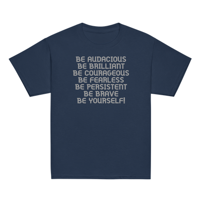 "Be Audacious Be Brilliant Be Courageous Be Fearless Be Persistent Be Brave Be Yourself!" printed on a navy youth classic tee laying on a flat surface