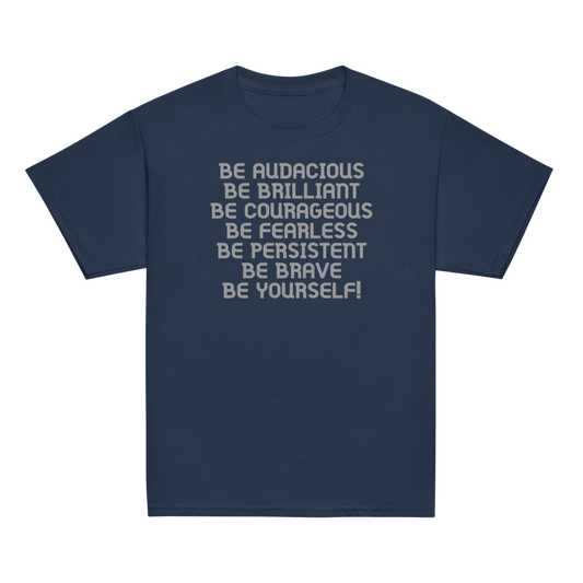 "Be Audacious Be Brilliant Be Courageous Be Fearless Be Persistent Be Brave Be Yourself!" printed on a navy youth classic tee laying on a flat surface