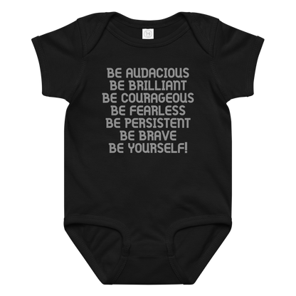 "Be Audacious Be Brilliant Be Courageous Be Fearless Be Persistent Be Brave Be Yourself!" printed on a black baby jersey bodysuit laying on a flat surface amongst other clothes