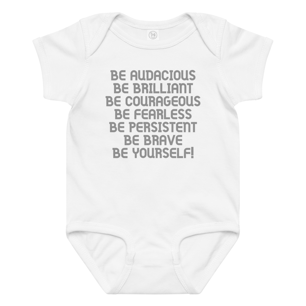 "Be Audacious Be Brilliant Be Courageous Be Fearless Be Persistent Be Brave Be Yourself!" printed on a white baby jersey bodysuit laying on a flat surface amongst other clothes