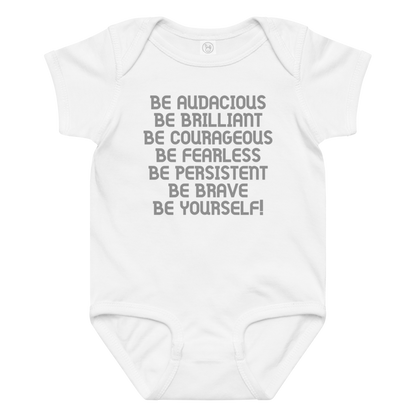 "Be Audacious Be Brilliant Be Courageous Be Fearless Be Persistent Be Brave Be Yourself!" printed on a white baby jersey bodysuit laying on a flat surface amongst other clothes