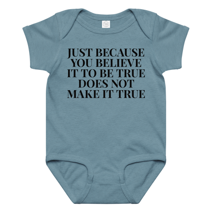 "Just because you believe it to be true does not make it true" printed on a vintage indigo baby jersey bodysuit laying on a flat surface amongst other clothes