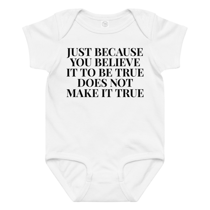"Just because you believe it to be true does not make it true" printed on a white baby jersey bodysuit laying on a flat surface amongst other clothes