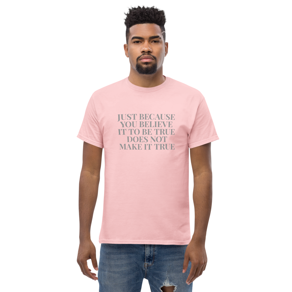 "Just because you believe it to be true does not make it true" printed on a light pink unisex classic tee worn by a male